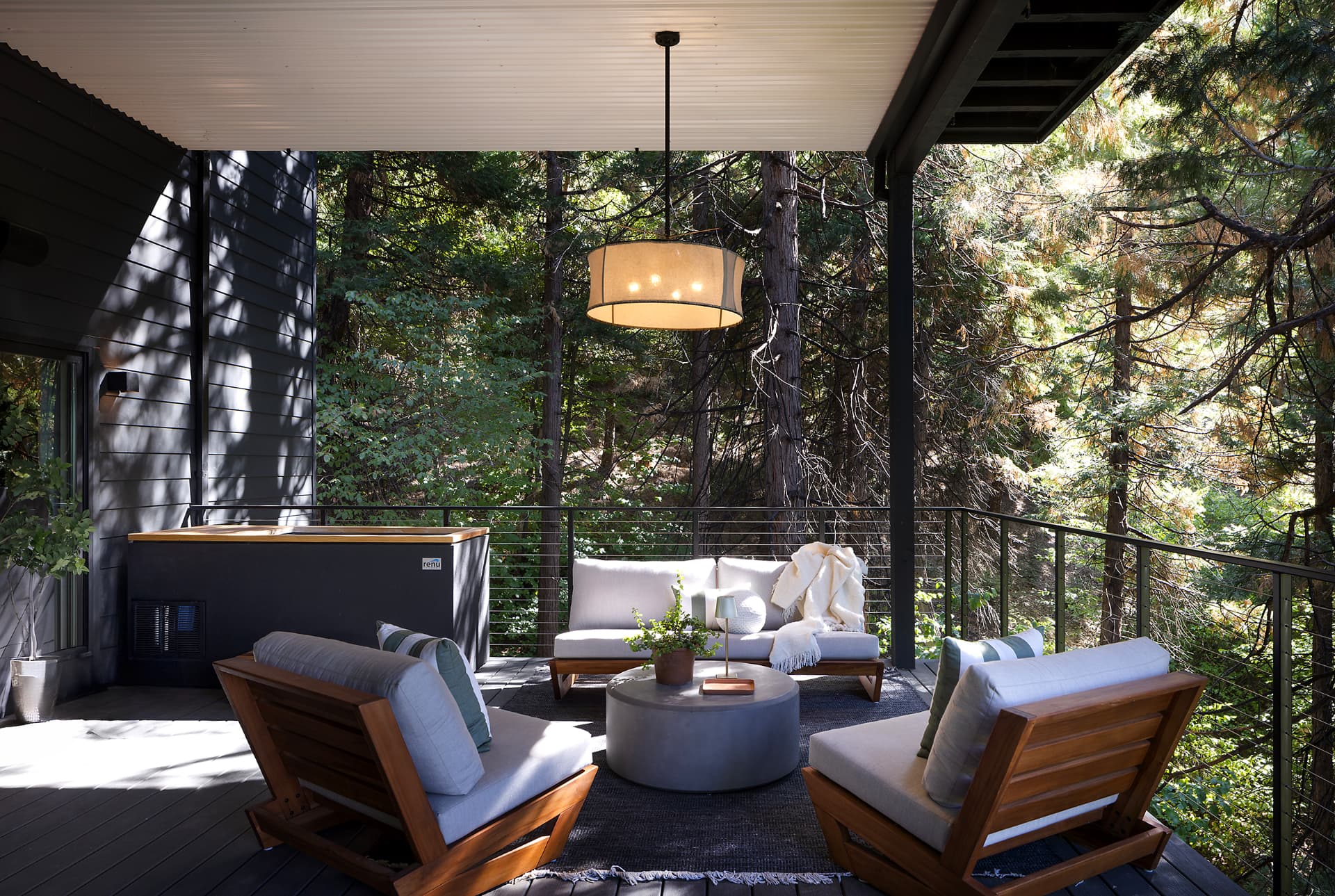 Cold plunge on the covered deck beside lounge seating and forest